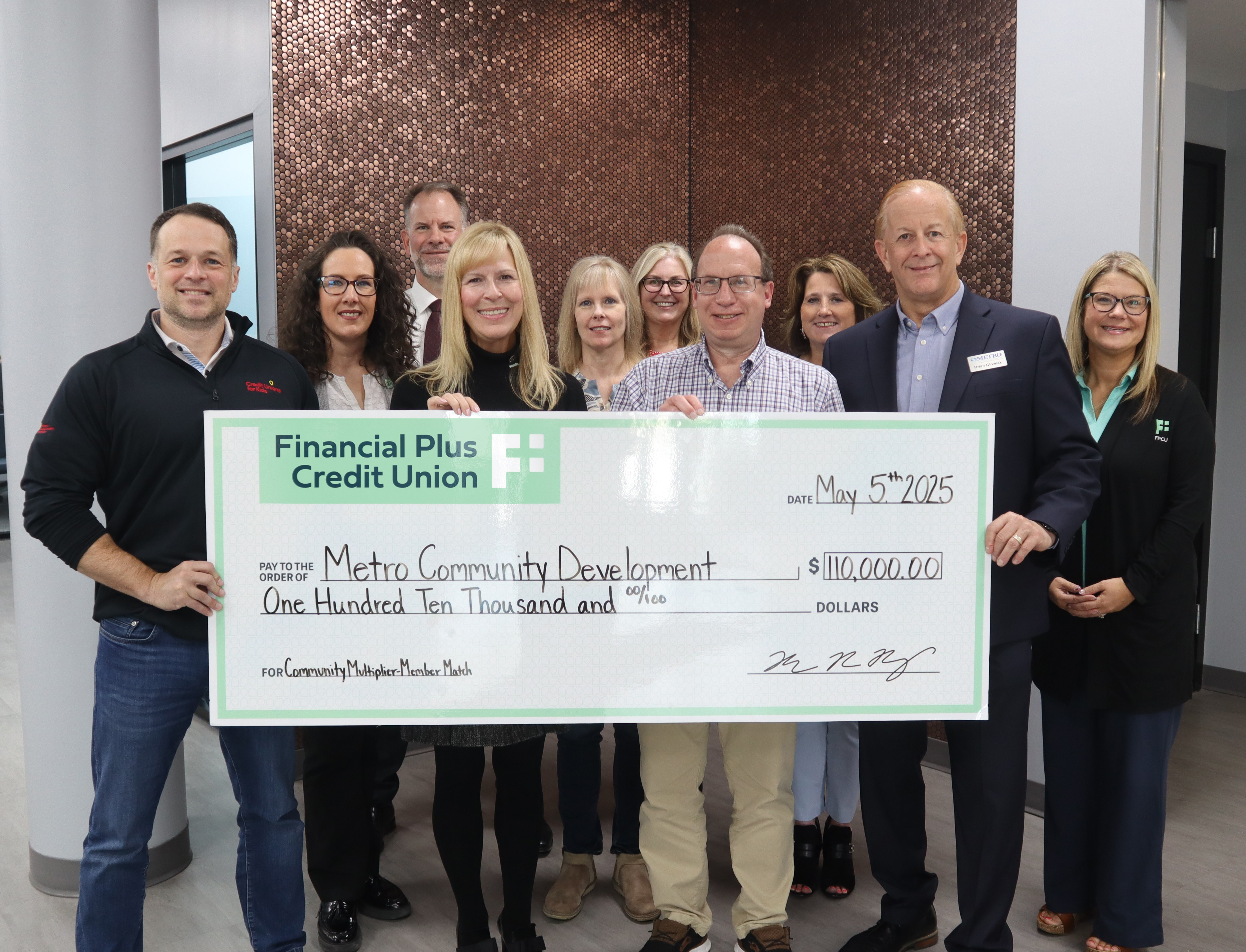 Financial Plus executives present Metro Community Development with a check for $110,000.