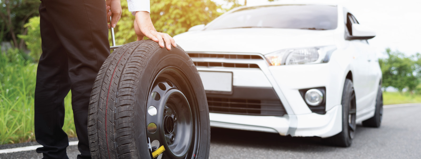 man with tire to fix car