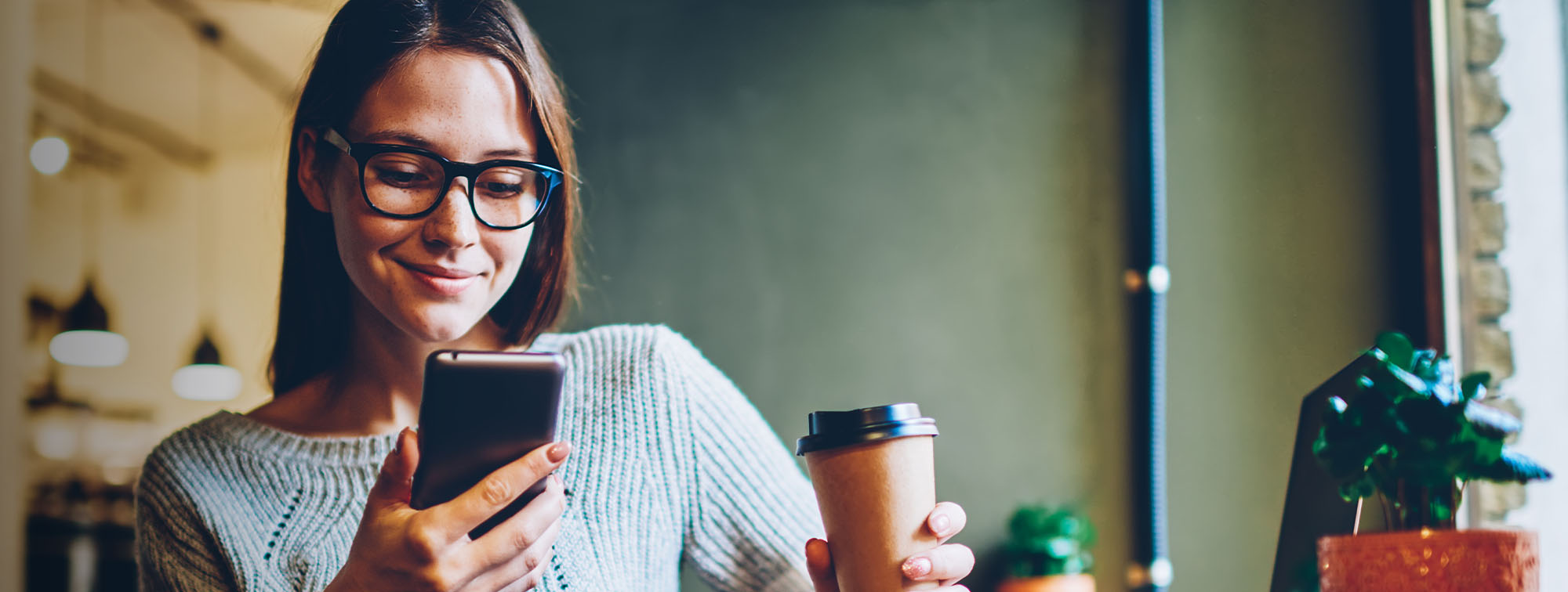 Woman reading her phone in a coffee shop