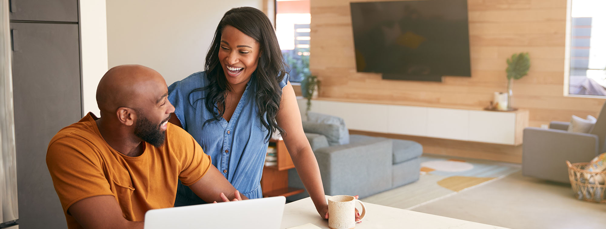 Couple laughing with one another as they use a computer