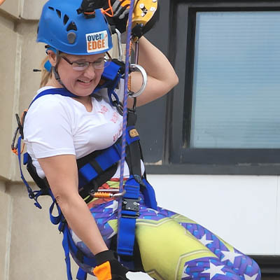 woman rappelling from building