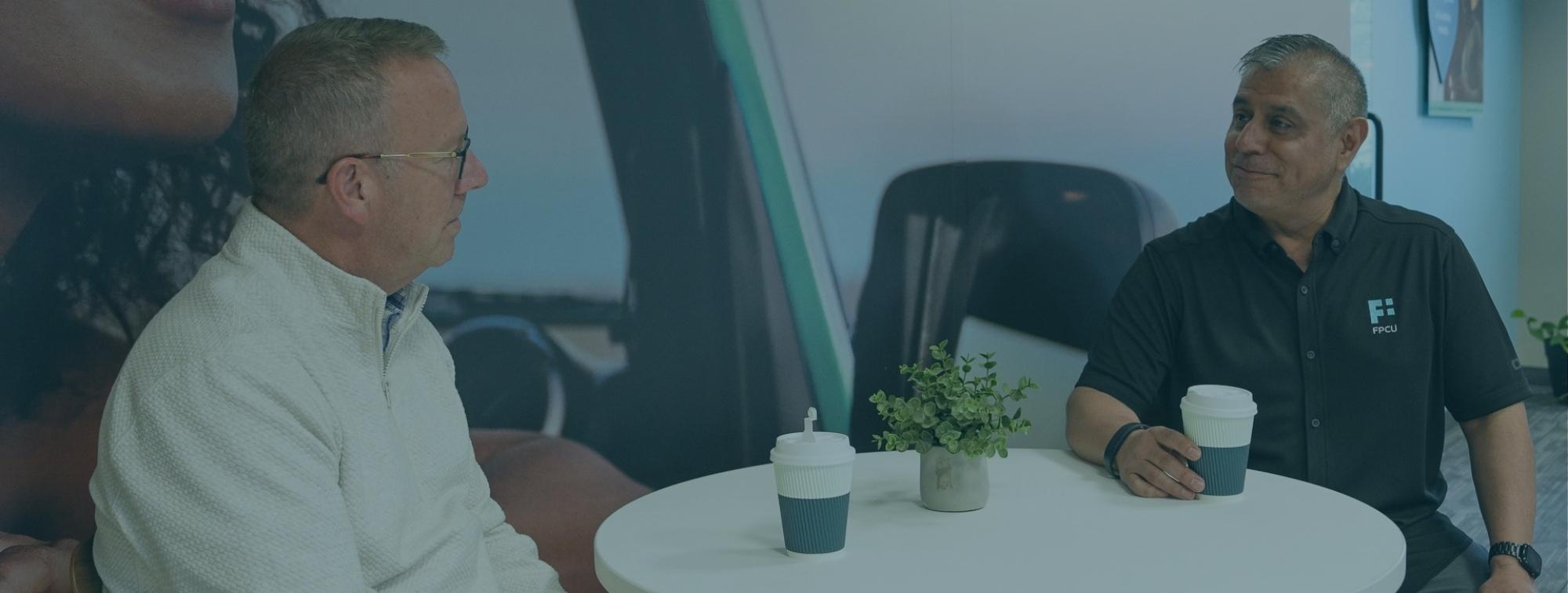 Two Financial Plus Credit Union Employees chatting over a cup of coffee