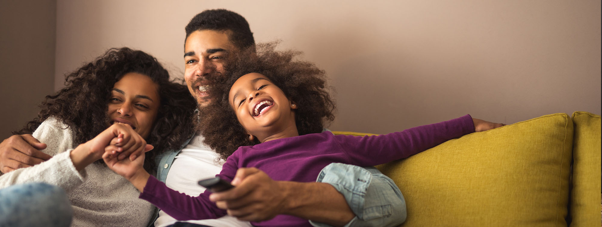 Young family cuddled together on a couch