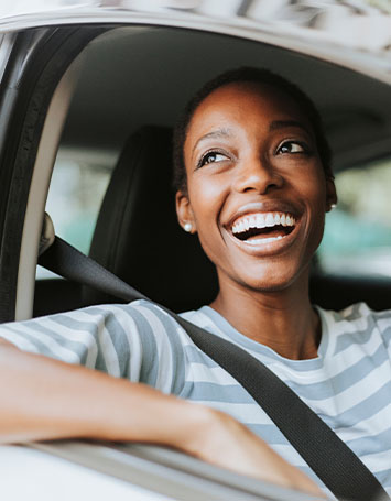 Woman looking out of her car smiling