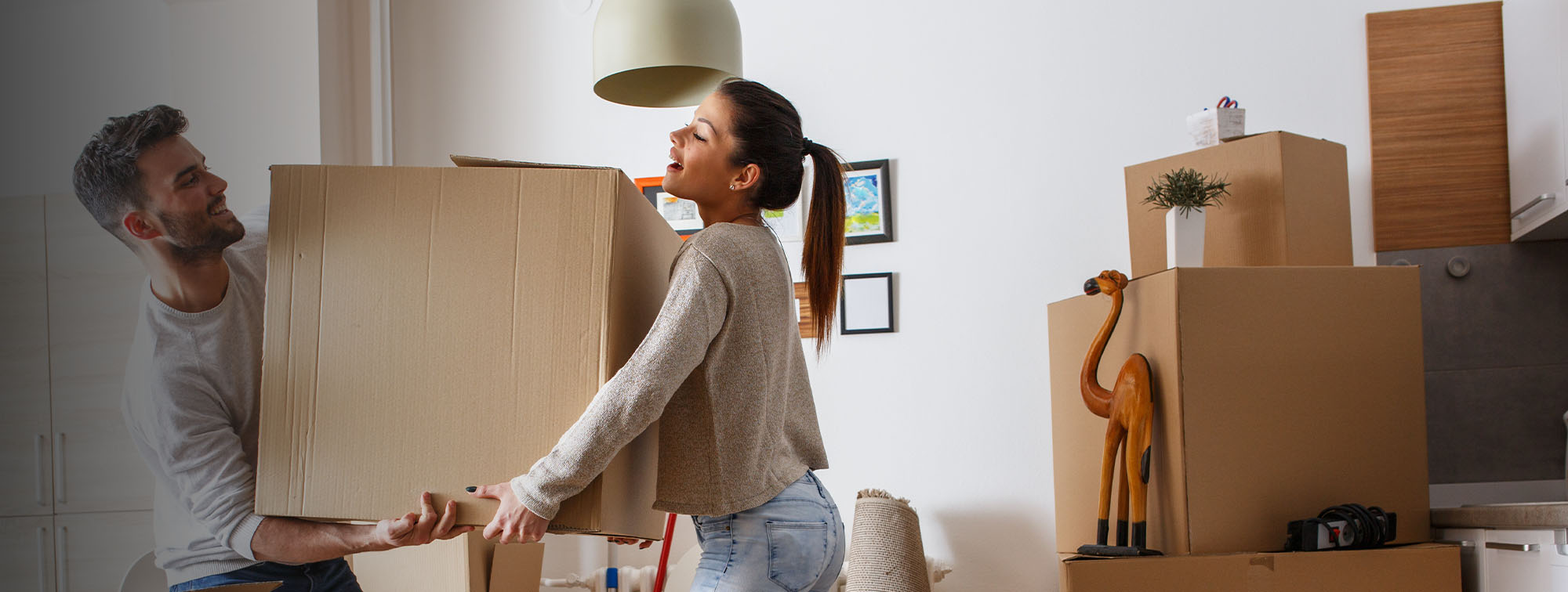 Couple moving large cardboard boxes