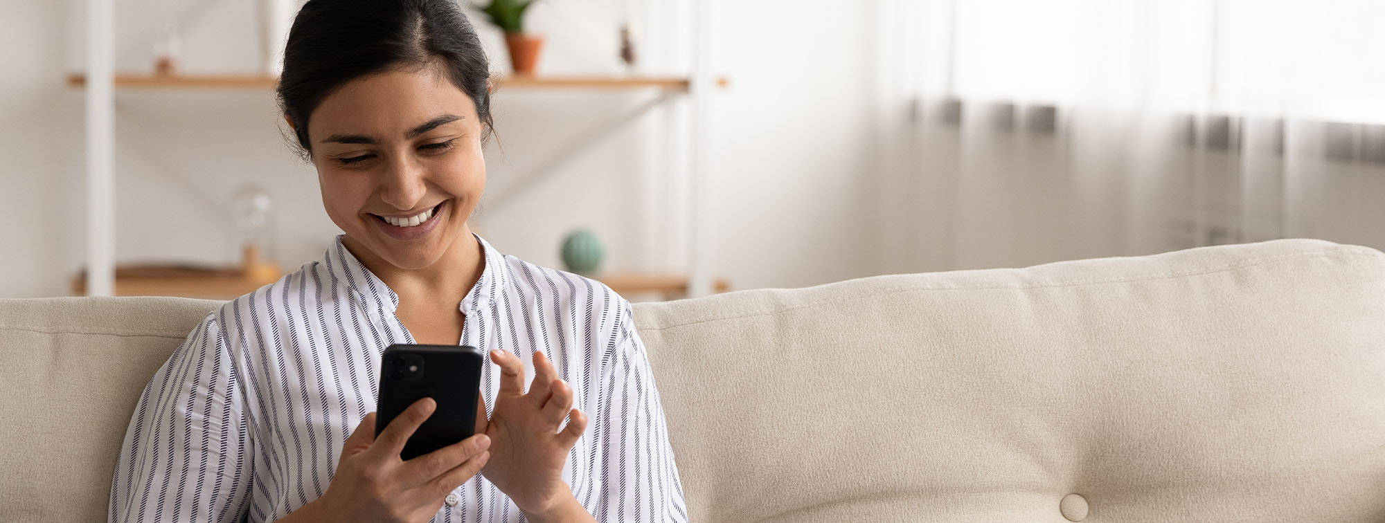 Woman using her phone on the couch