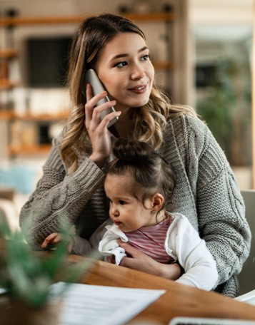 mother sitting with daughter and talking on the phone